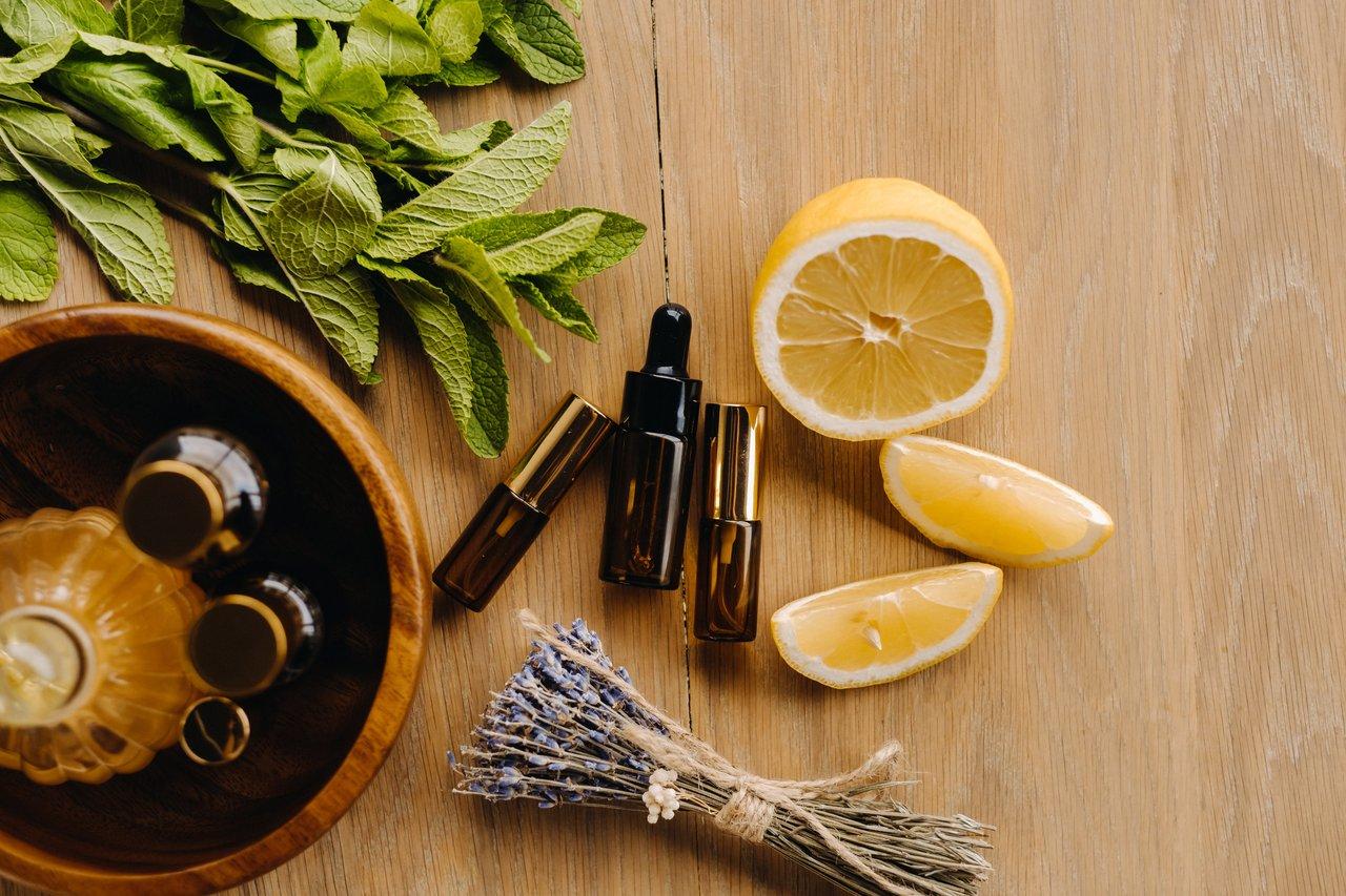 Composition de flacons d’huiles essentielles sur une table en bois, ambiance cocooning pour une aromathérapie naturelle.