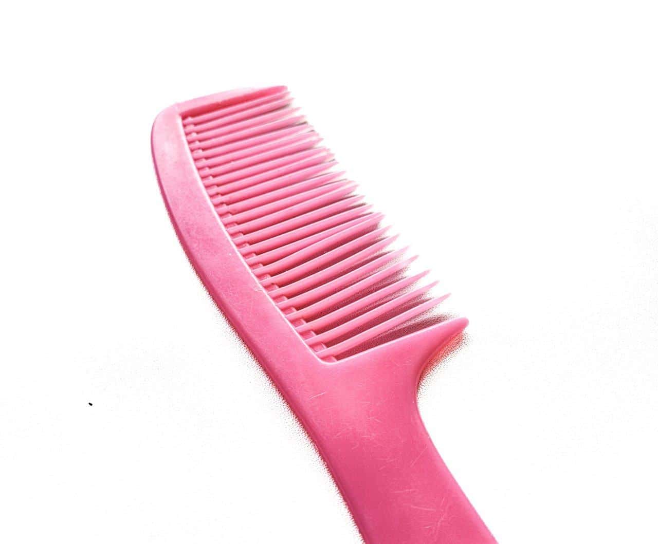 Peigne à dents larges dans une salle de bain naturelle, essentiel pour démêler les cheveux humides en douceur.