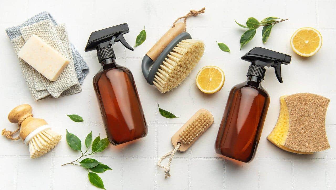 Une jeune femme prépare un mélange homemade natural cleaning avec vinaigre, citron et savon de Marseille.