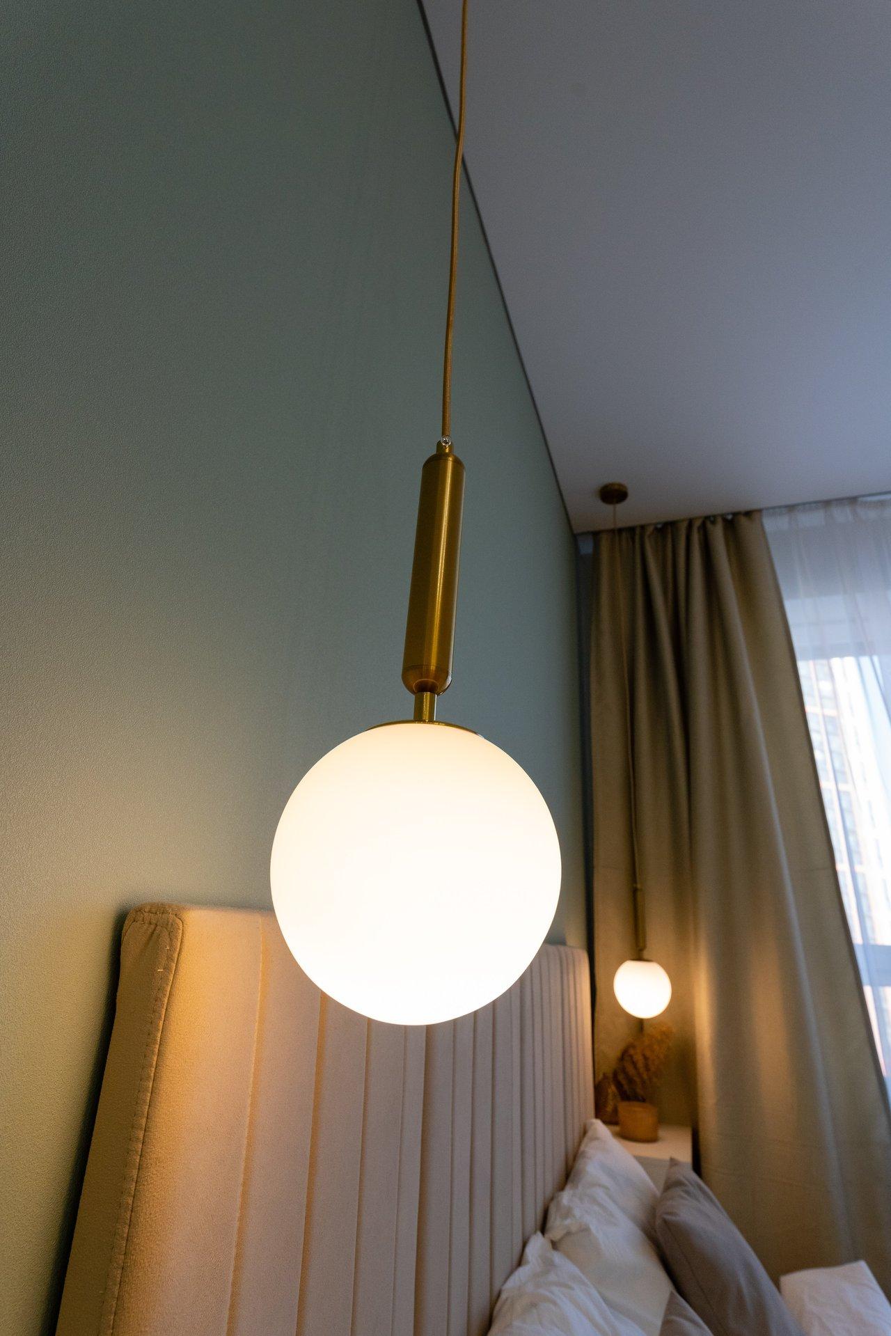 Une chambre paisible avec un éclairage tamisé, un lit confortable et un oreiller adapté pour un sommeil réparateur.