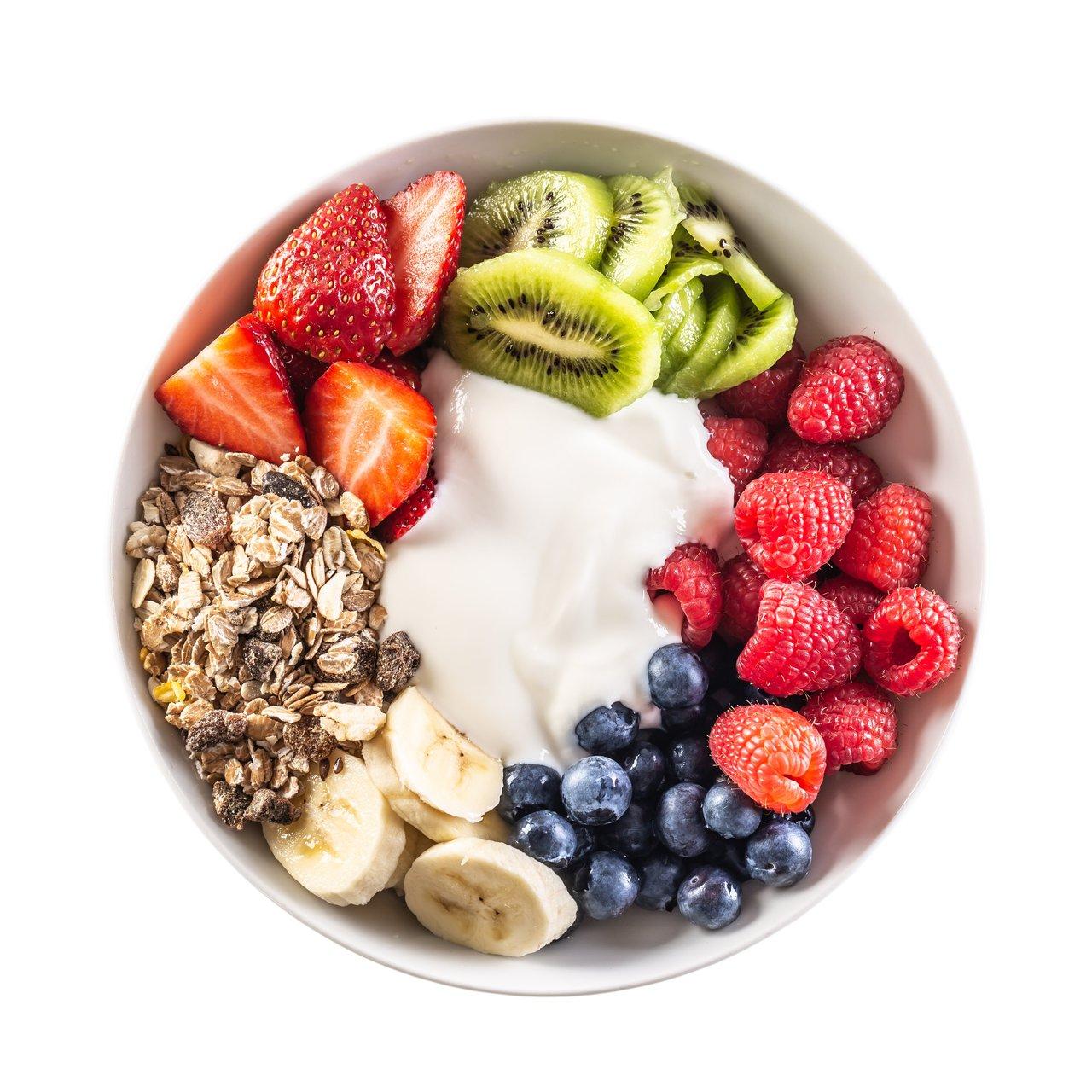 Bol de yaourt blanc garni de super aliments : baies de goji, graines de chia et noix pour un petit-déjeuner sain.