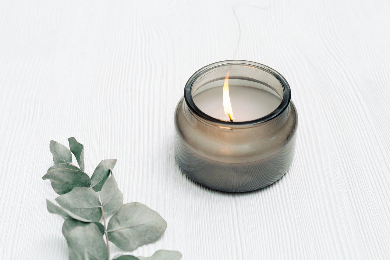 Une bougie parfumée dans un wellness journal évoque une routine de détox émotionnelle apaisante.