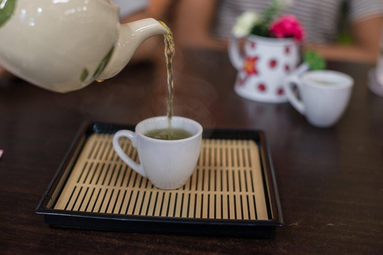 Une tasse de thé vert fumant sur une table en bois, idéale pour stimuler la santé du cerveau.